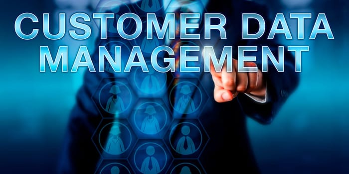 Manager is touching CUSTOMER DATA MANAGEMENT onscreen. Male and female corporate customer icons arranged in a hexagonal planning matrix do represent structured customer data. Business concept.