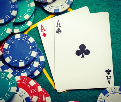 Stack of chips and two aces on the table on the green baize - poker game concept