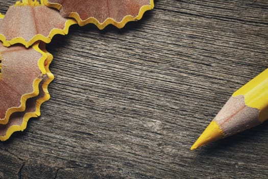 pencil and shavings on wooden background, space for your text