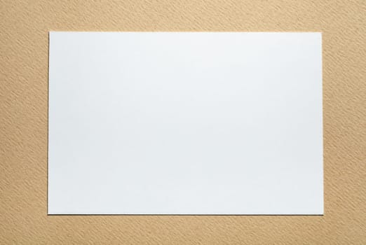 white paper card on beige background, place for tex
