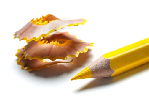 yellow pencil and shavings on white background