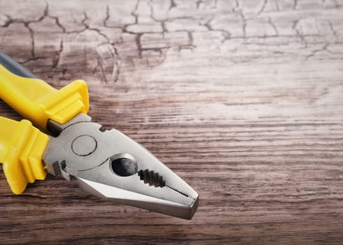 Close up of a multitool pliers on wooden background
