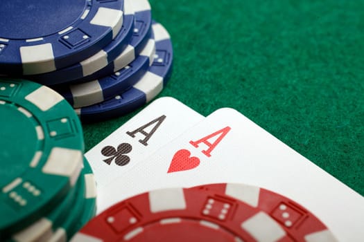 Stack of chips and two aces on the table on the green baize - poker game concept