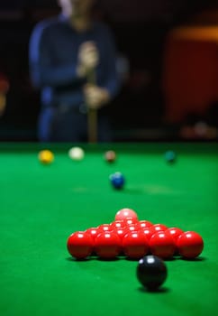 A young man lines up his shot as he breaks the balls for the start of a game of snooker