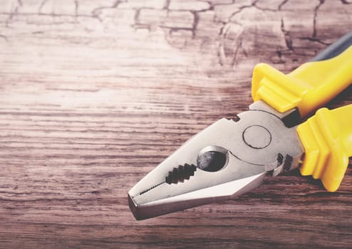 Close up of a multitool pliers on wooden background