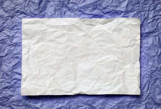 Crumpled  white paper card on violet  background, place for tex