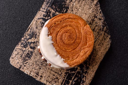 Round sweet New York roll croissant with pistachio cream filling on a dark concrete background