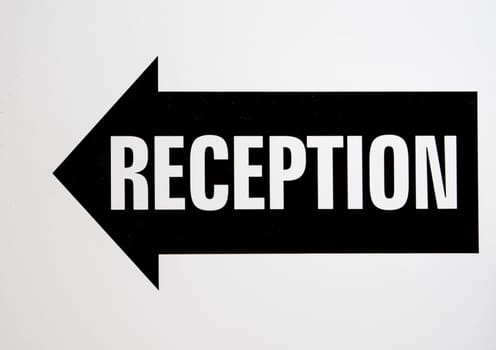 Hotel reception signage in balck and white. Reception is in an arrow