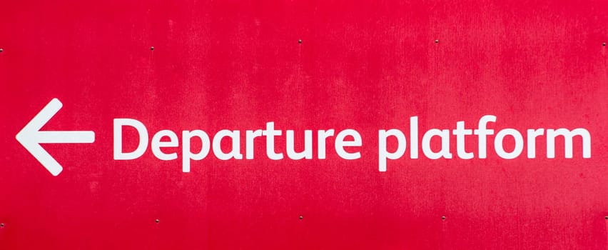 Vivid red sign pointing towards the Departure Platform