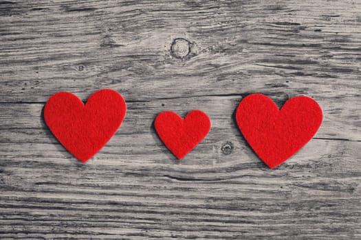 red hearts on a wooden surface background