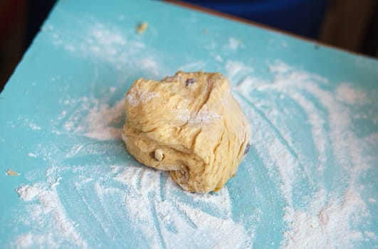 The dough with flour on the blue table
