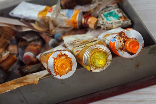 Old Paint tubes on painted tool background