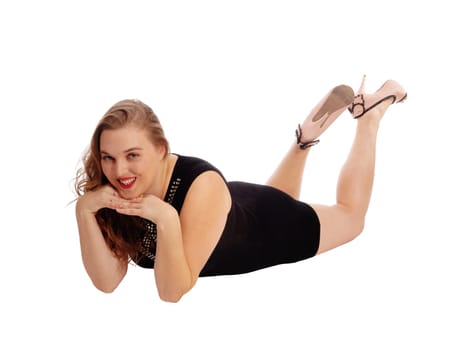 A pretty woman in a black dress lying on the floor with her hands under.her chin, isolated for white background..