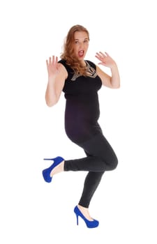A blond young woman in black tights dancing with her hands raised.looking into the camera, isolated for white background..