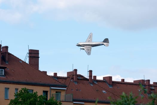 The raisin bomber throws small screens while flying over the former apron of Tempelhof airport for the 60th anniversary of the airlift celebration in Berlin-Tempelhof