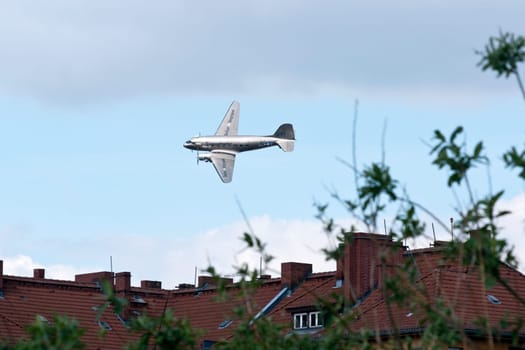 The raisin bomber throws small screens while flying over the former apron of Tempelhof airport for the 60th anniversary of the airlift celebration in Berlin-Tempelhof