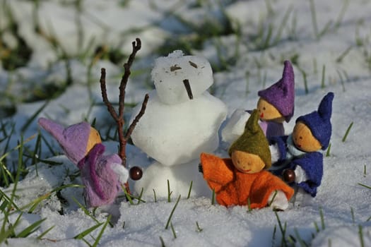 Four little gnomes build a snowman