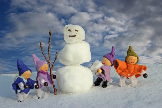 Four little gnomes build a snowman