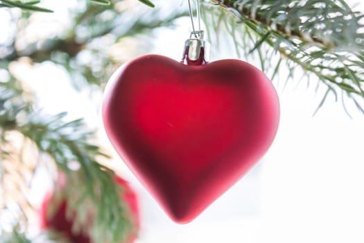 A red heart hangs on a Christmas tree,romantic close-up