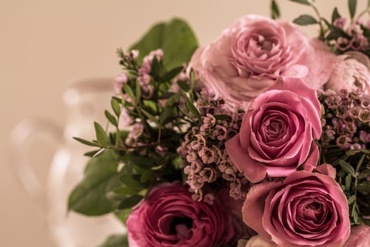 A great bouquet of roses in rose tones lies on the table waiting to be given away