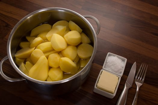 In a cooking pot,silver,freshly peeled potatoes lie in the water. So the supplement will be a pleasure!