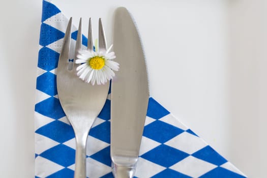 It's done - food in Bavaria! A cutlery with daisies on a white-blue napkin