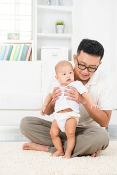 Asian father and baby boy playing at home. Family lifestyle indoors.