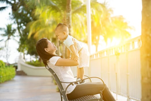 Mother and son having fun at outdoor in sunset during holidays.