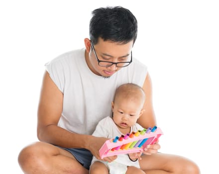 Father and baby playing music instrument. Sound development concept. Asian family lifestyle isolated on white background.