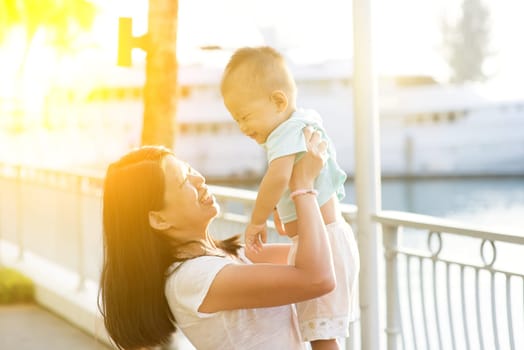 Asian mother and son having fun at outdoor in sunset during vacations.