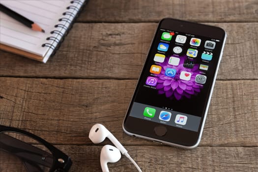 Bangkok, Thailand - feb 15, 2016 : iphone 6 and ios application on wood desk, iphone 6 developed by apple Inc.