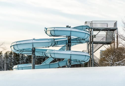 Water Slide in Winter with Snow and a cloudy sky.