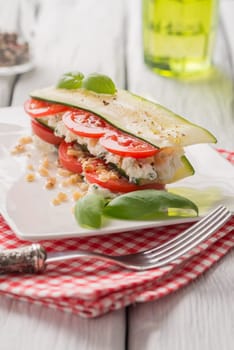 Delicious Italian appetizer of tomato, zucchini slices, nuts, basil and fresh cheese.