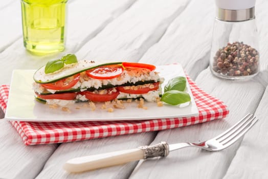 Delicious Italian appetizer of tomato, zucchini slices, nuts, basil and fresh cheese.
