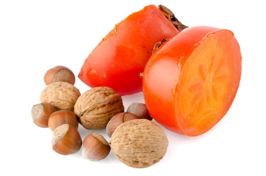 Ripe persimmons and nuts on white background.
