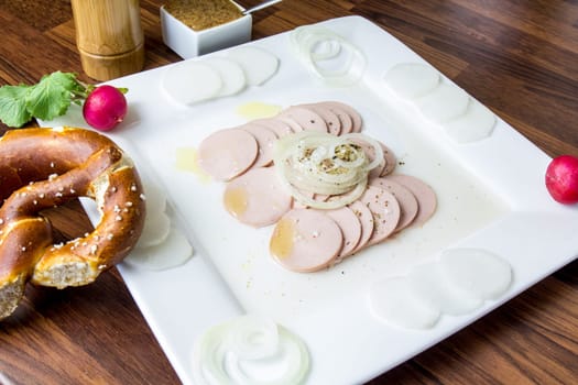 The Bavarian sausage salad is a meal with sausage,a Lyon,onions,vinegar and oil.