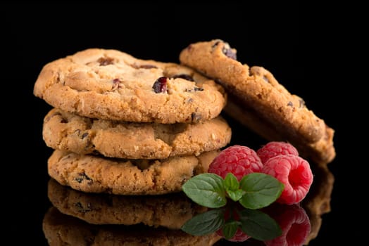 Dried fruits chip cookies and raspberries isolated on black background.