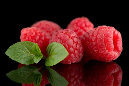 Raspberries with leaves isolated on black background background