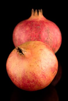 Ripe pomegranate fruits with leaves on black background