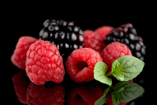 Composition from a blackberry and raspberry on the black isolated background