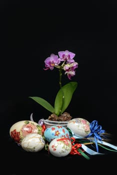 Easter eggs handmade with original decorations and colored ribbons. Black background.