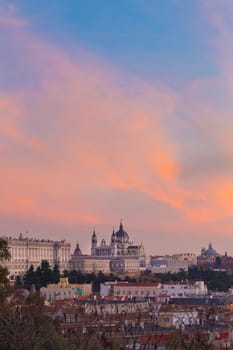 Madrid, Spain skyline at Santa Maria la Real de La Almudena Cathedral and the Royal Palace in vivid colorful sunset.