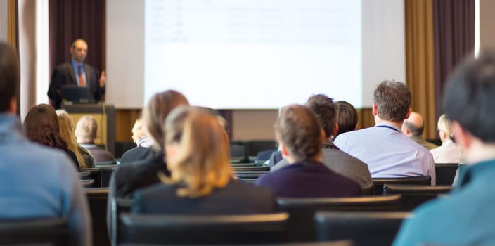 Speaker Giving a Talk at Business Meeting. Audience in the conference hall. Business and Entrepreneurship. Panoramic composition suitable for banners.