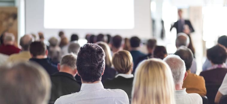 Speaker Giving a Talk at Business Meeting. Audience in the conference hall. Business and Entrepreneurship. Panoramic composition suitable for banners.