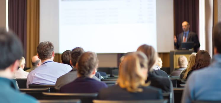 Speaker Giving a Talk at Business Meeting. Audience in the conference hall. Business and Entrepreneurship. Panoramic composition suitable for banners.