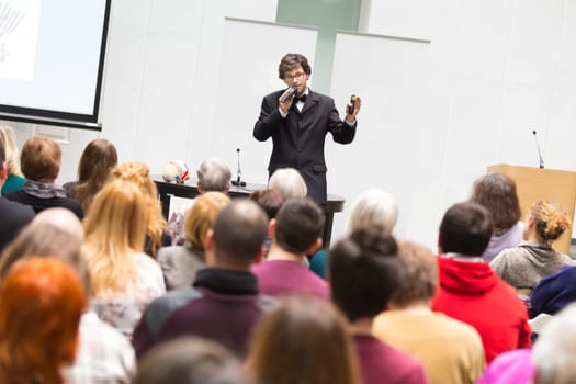 Speaker Giving a Talk at Business Meeting. Audience in the conference hall. Business and Entrepreneurship. Copy space on white board.