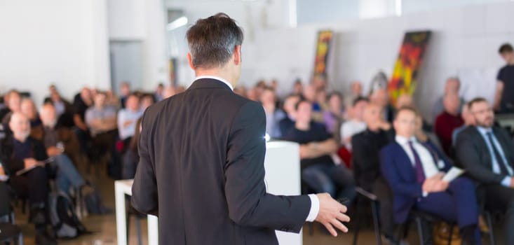Speaker at Business Conference with Public Presentations. Audience at the conference hall. Business and Entrepreneurship concept. Background blur. Shallow depth of field.