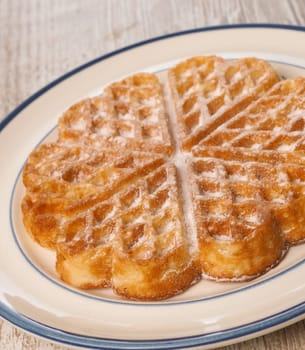 Sweet waffle on a rustic plate in a kitchen