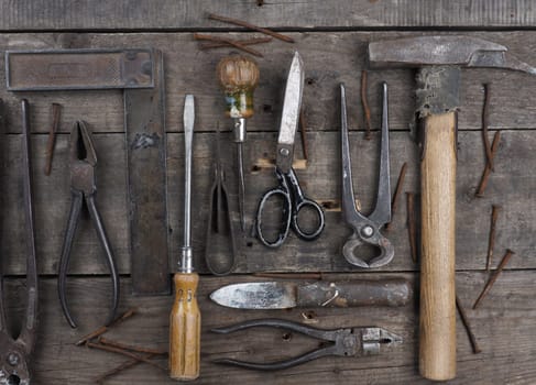 Old and rusty used tools on a rustic wooden table