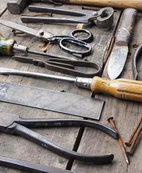 Old and rusty tools on a rustic wooden table